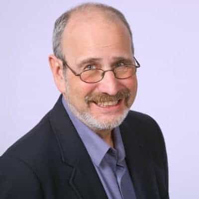 Richard Reeder, smiling, wearing glasses and a blue shirt